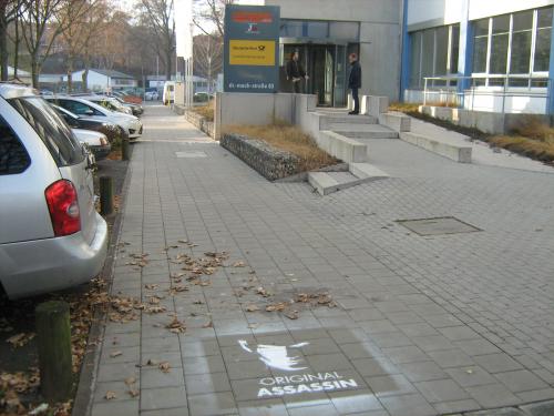 Wer hat vor dem Computec-Verlagsgebäude sein Unwesen getrieben? Vor dem Eingang findet sich ein Graffiti mit dem Schriftzug 'Original Assassin' und ein Logo.