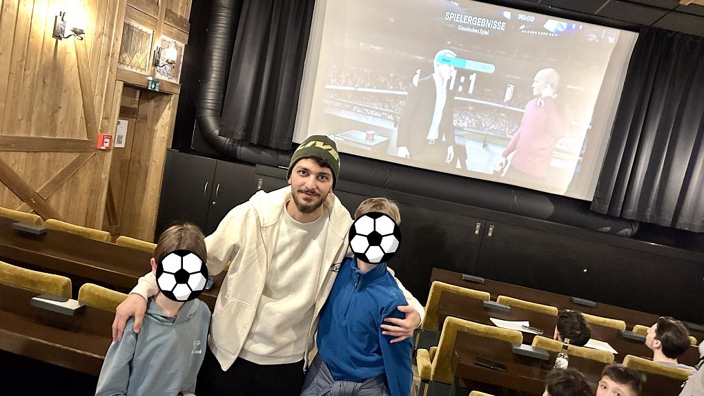 FIFA-Spieler Canik posiert mit Kindern für ein Foto.