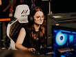 Spielerin sitzt an PC, Spiel im Vordergrund