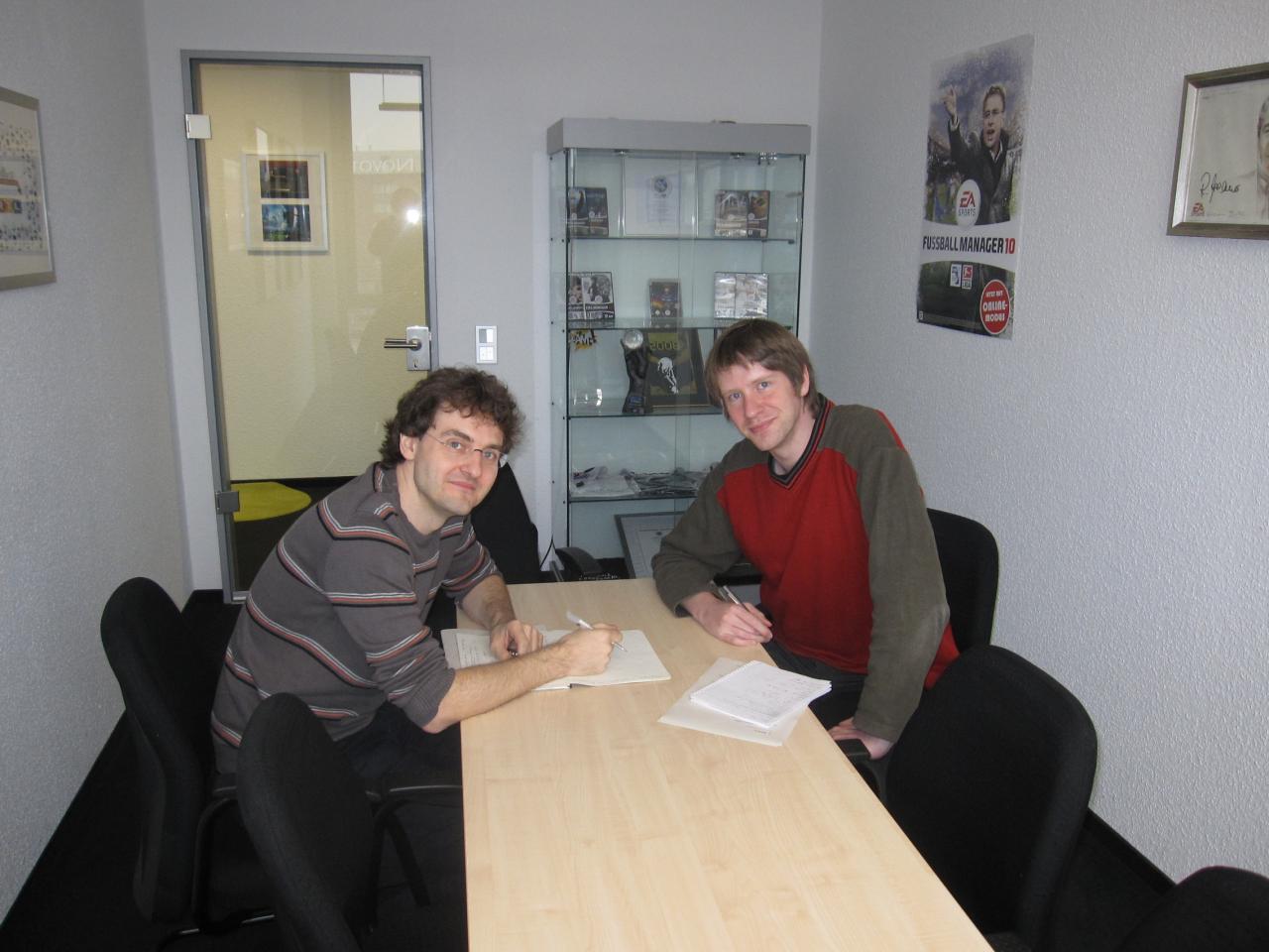 [17/11/2009] Die Arbeit hört nie auf, kaum ist die Diskussion in der QA beendet, gibt es auch schon ein Design-Meeting mit FM-Urgestein Gerald Köhler. Im Hintergrund ist eine Vitrine mit Deutschen Entwicklerpreisen, BÄM-Award und anderen Auszeichnungen zu erkennen. Wer hat, der hat.
