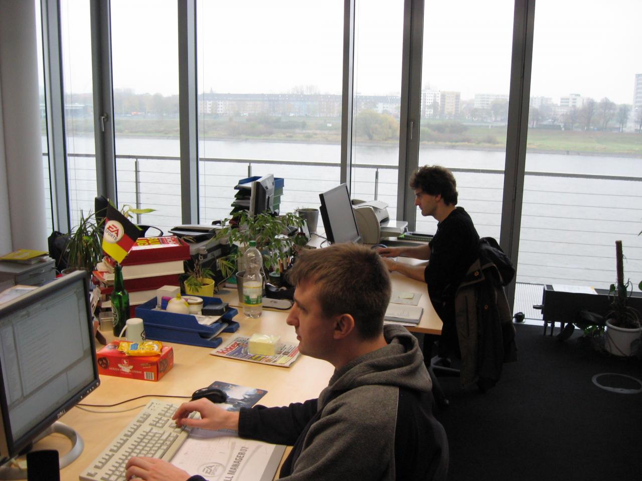 [17/11/2009] Hier sehen wir die „Taskforce Textmodus“ bestehend aus Jörg Eschmann und Gerald Köhler, deren Hauptaufgabe darin besteht, den vorhandenen Textmodus zu optimieren. Die harte Arbeit wird durch einen wunderbaren Rheinblick, exotischen Topfpflanzen und Weihnachtsgebäck versüßt.