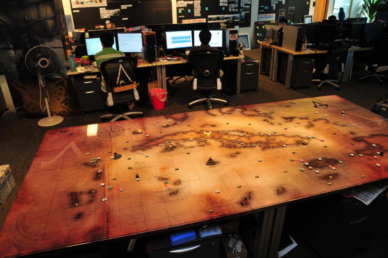 [05/08/2013] Dieser Tisch wurde vom Art Director Mufi zal Mokhtar als Hobbyprojekt gebaut. Er zeigt eine handgemalte Karte der Karibik-Spielwelt. Überall im Studio von Ubisoft Singapur erblicken wir Hinweise auf die Themen Seefahrt und Ozean.