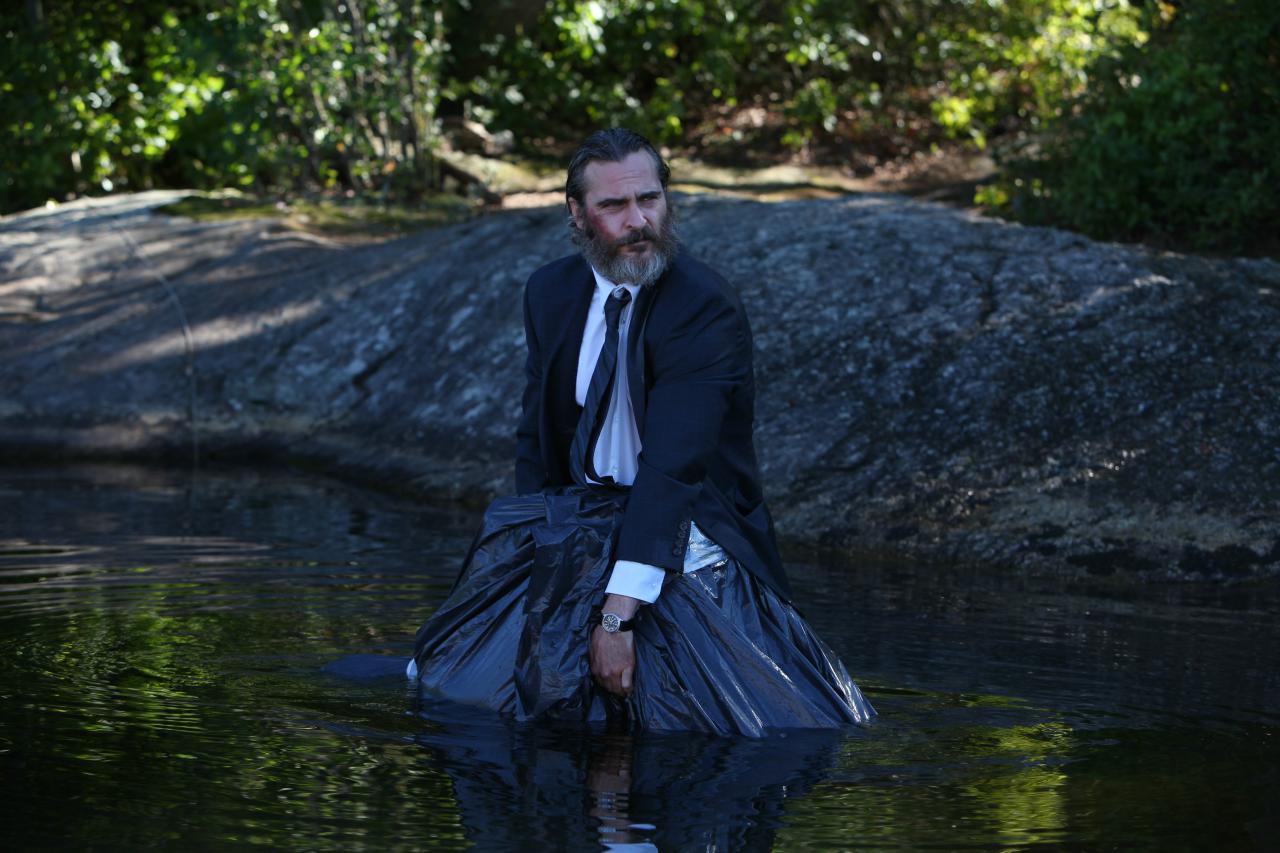 Szenenbild: "A Beautiful Day" (2018) - Joe steht mit einem Müllsack im Wasser.