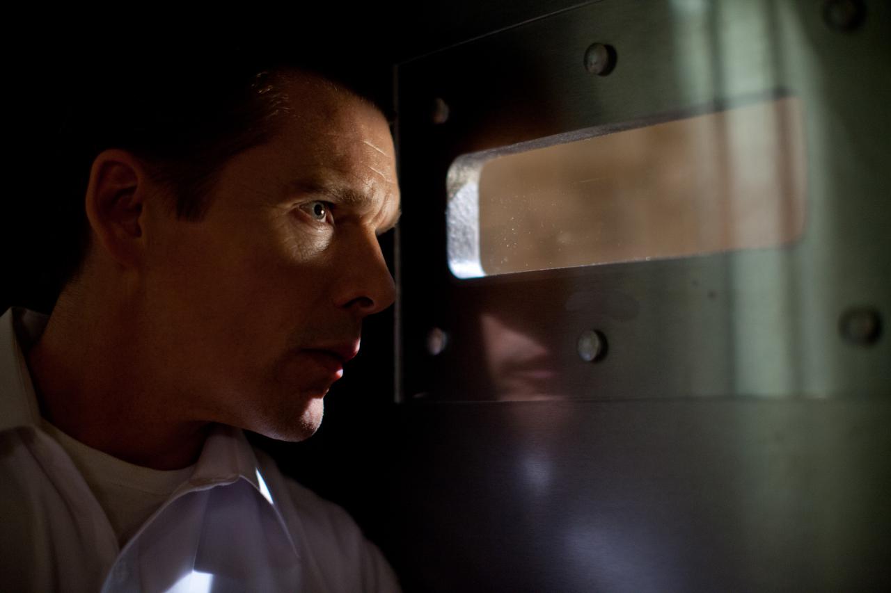 Szenenbild "The Purge - Die Säuberung" (2013) - Der Familienvater (Ethan Hawke) schaut verunsichert durch den Schlitz seiner Sicherheitstür