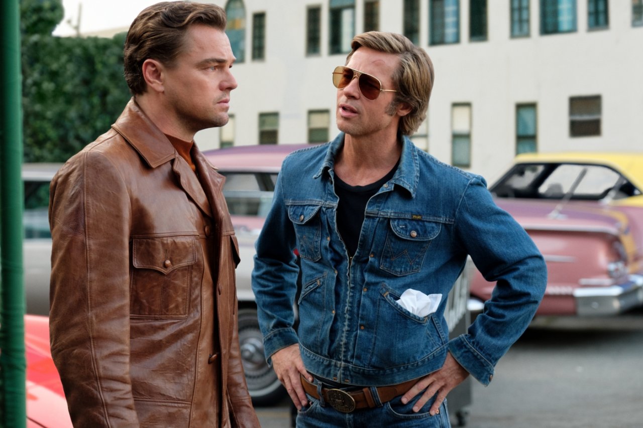 Rick Dalton (Leonardo DiCaprio) und Cliff Booth (Brad Pitt) stehen auf einem Parkplatz.