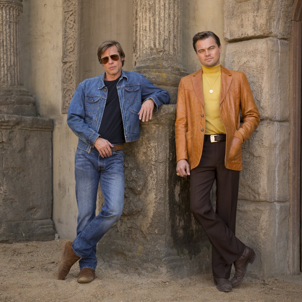 Brad Pitt und Leonardo DiCaprio posieren vor einer Wand