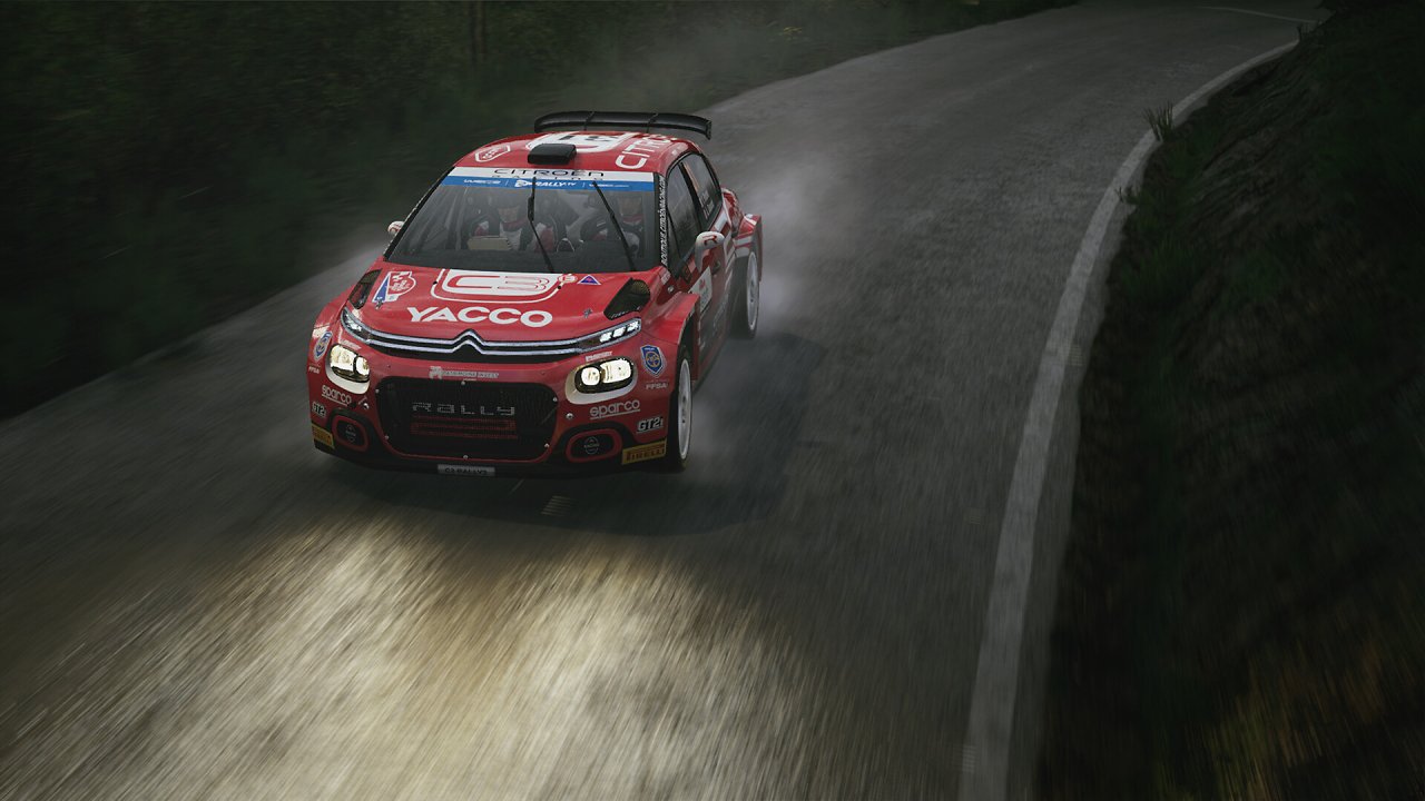 Ein Rennauto fährt über eine nächtliche Rallyepiste.