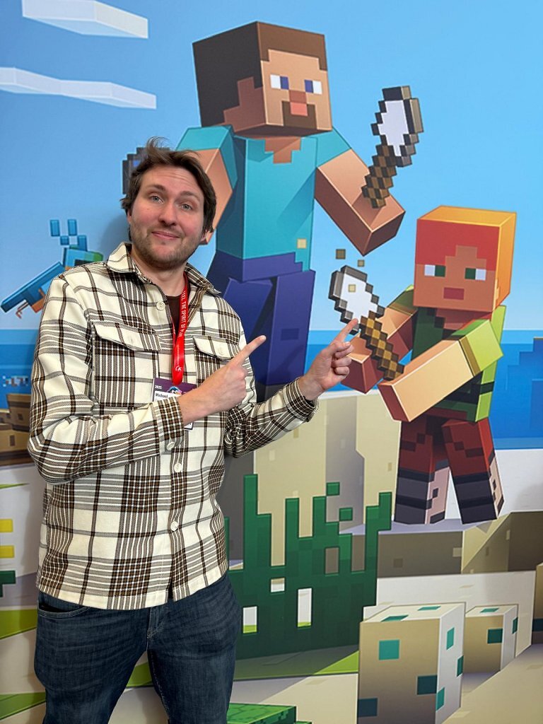 Redakteur Michi Grünwald auf der Spielwarenmesse vor einem Minecraft-Hintergrund