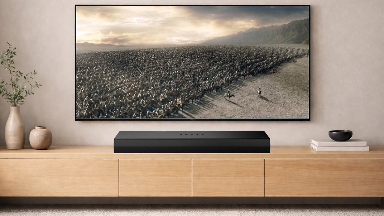 Ein TV hängt an der Wand und zeigt Herr der Ringe, darunter steht eine Soundbar.