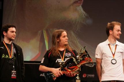 Socke (Mitte) freut sich über den Pokal in Starcraft 2. Im letzten Spiel domonierte er ClouD (links) mit 2:0.