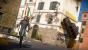 <strong>Häuserwände mit Autos tapezieren</strong> - Die Seile, die Rico Rodriguez in Just Cause 3 mit seiner Armvorrichtung verschießt, sind super-reißfest. Daher ist es für ihn auch kein Problem, tonnenschwere Objekte wie Jeeps an Gebäude zu kleben. Der Haftwirkung seiner Stahlseile ist kein Fahrzeug gewachsen. Wer anschließend umdekorieren will, kann die Auto-Tapete ja stilecht mit einer C4-Ladung wegsprengen!