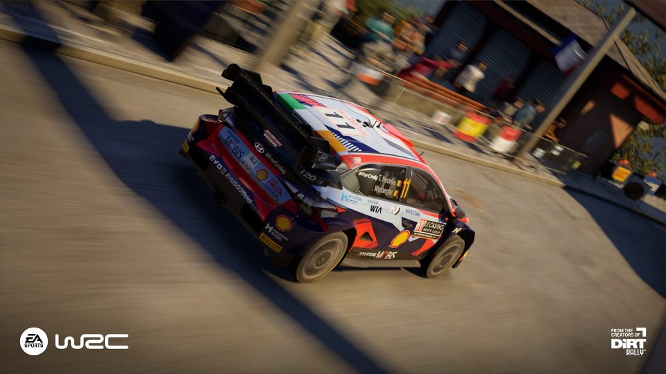 Ein Rallye-Wagen rast über eine Asphaltstrecke.