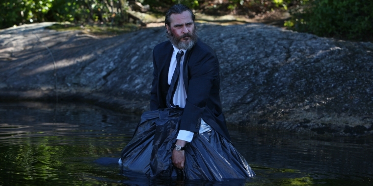 Szenenbild: "A Beautiful Day" (2018) - Joe steht mit einem Müllsack im Wasser.